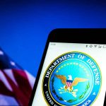 Smartphone showing Department of Defense logo, American flag background.