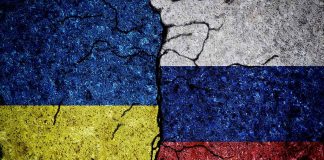 Cracked Ukrainian and Russian flags painted on concrete.