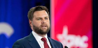 Man in suit speaking at podium.