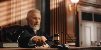Judge holding gavel in courtroom.