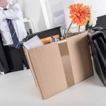 Cardboard box with office items and flowers