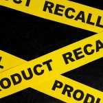 Yellow product recall tape on black background