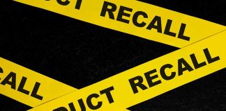 Yellow product recall tape on black background