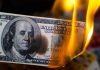 Burning hundred dollar bill with visible flames