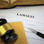 Lawsuit document with gavel pen and open book