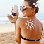 Woman applying sunscreen at the beach