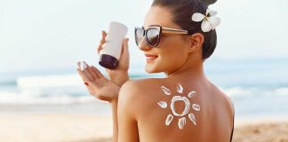Woman applying sunscreen at the beach