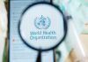 Magnifying glass focused on World Health Organization logo