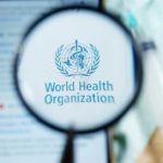 Magnifying glass focused on World Health Organization logo