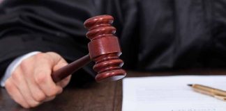 Judges hand holding a gavel near documents