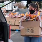 Person carrying food bank box to car