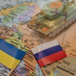 Toy tank on map with Ukraine and Russia flags