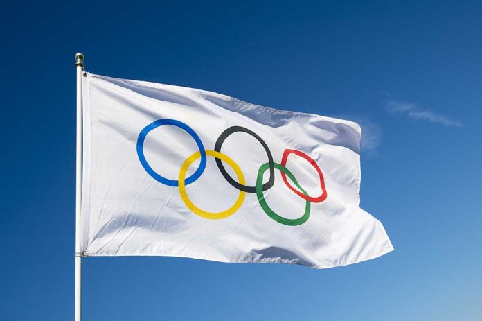 430080421 featured image Olympic flag waving against clear blue sky.