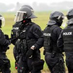 Police officers in tactical gear standing together outdoors