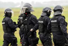 Police officers in tactical gear standing together outdoors