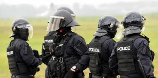 Police officers in tactical gear standing together outdoors