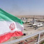 Iranian flag near an industrial gas refinery