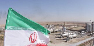 Iranian flag near an industrial gas refinery