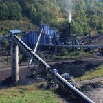 Industrial coal processing plant with conveyor belts and smokestack