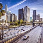 Downtown cityscape with skyscrapers and highway traffic