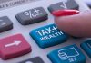 Finger pressing calculator tax and wealth button