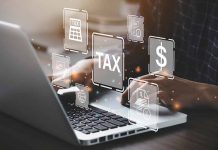 Person typing on laptop with tax related icons displayed