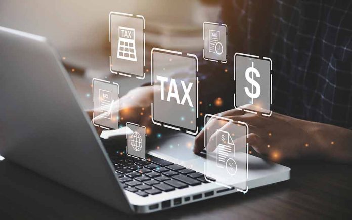 Person typing on laptop with tax related icons displayed