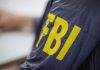 Person wearing jacket with FBI in yellow letters