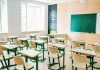 Empty classroom with desks facing a chalkboard
