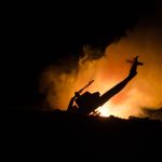 Silhouette helicopter with fire and smoke background