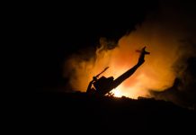 Silhouette helicopter with fire and smoke background