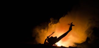 Silhouette helicopter with fire and smoke background