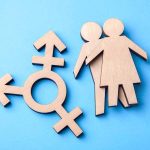 Wooden transgender symbol and couple figures on blue background