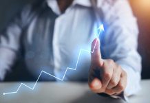 Person pointing at an upward trend line graph
