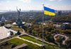 Large Ukraine flag with cityscape in background