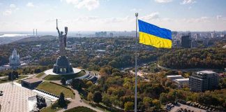 Large Ukraine flag with cityscape in background