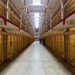 Long hallway with prison cells on both sides