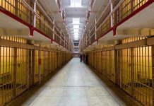 Long hallway with prison cells on both sides