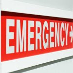 Emergency sign indicating direction with a red background and white text