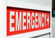 Emergency sign indicating direction with a red background and white text