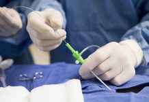 Medical professional preparing an intravenous catheter in a sterile setting