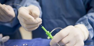 Medical professional preparing an intravenous catheter in a sterile setting