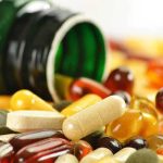 Assorted vitamins and supplements scattered around an overturned bottle