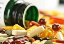 Assorted vitamins and supplements scattered around an overturned bottle
