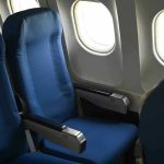 Empty airplane seats next to windows.