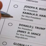 Hand holding pen near presidential election ballot.