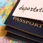 Stack of passports with a note labeled 'deportation' on top, placed on a map