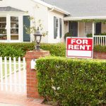 A house with a For Rent sign in the front yard