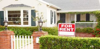 A house with a For Rent sign in the front yard