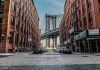 Street view with bridge between two brick buildings